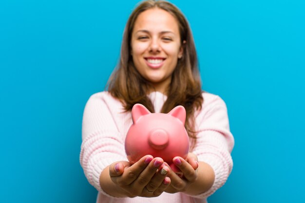 Young woman with a piggy bank  blue 