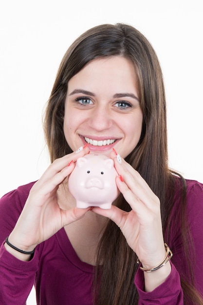 Young woman with piggy bank isolated on white