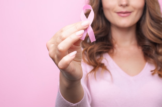 照片年轻女子与一个粉红丝带支持乳腺癌意识