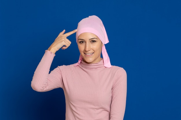 Young woman with pink scarf on the head on a blue