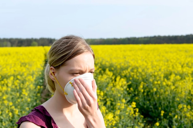 Young woman with pollution mask standing at field