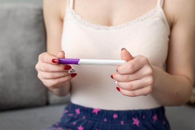 Giovane donna con test di gravidanza nelle mani