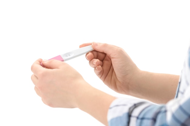 白い背景のクローズ アップの妊娠検査を持つ若い女性婦人科と出産