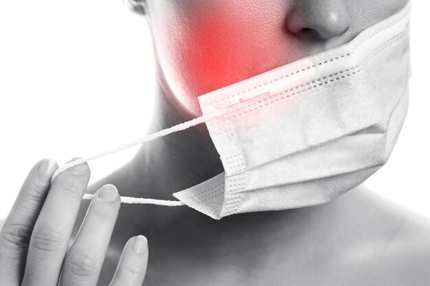 Photo young woman with prevention mask and skin irritation on white background. maskne - acne breakouts from wearing a face mask.