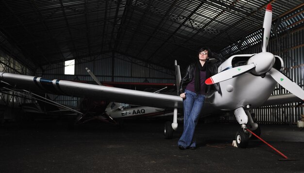 Photo young woman with private airplane