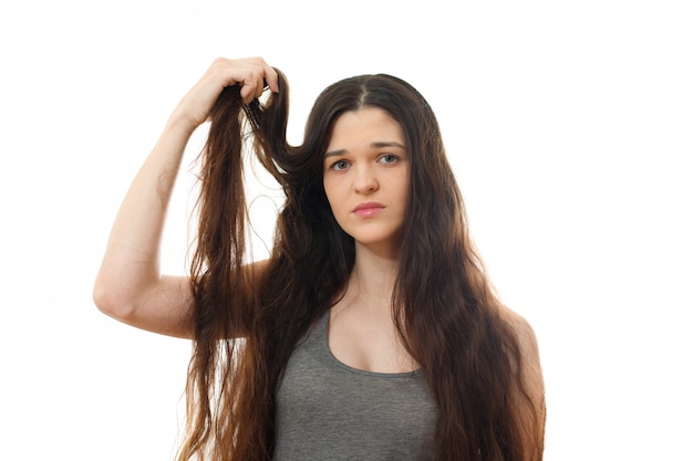 Young woman with problem hair. On white isolated