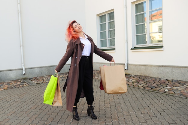 Young woman with red hair holds in her hands the packages after shopping