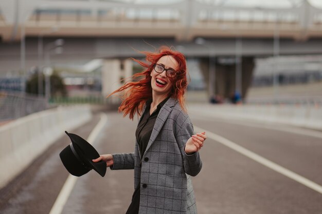 Young woman with red hair laughing with braces