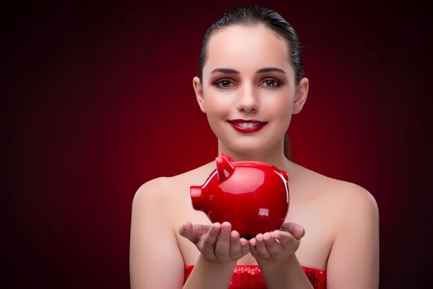 Young woman with red piggybank