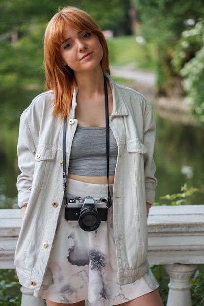 Young woman with retro camera in the park