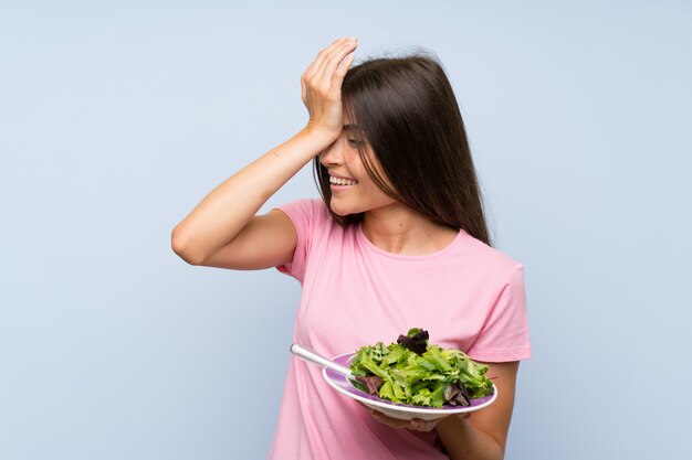 Young woman with salad has realized something and intending the solution