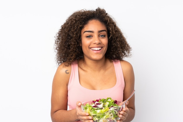 Young  woman with salad isolated on white wall