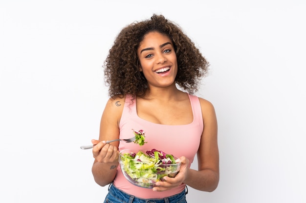 Young  woman with salad isolated on white wall