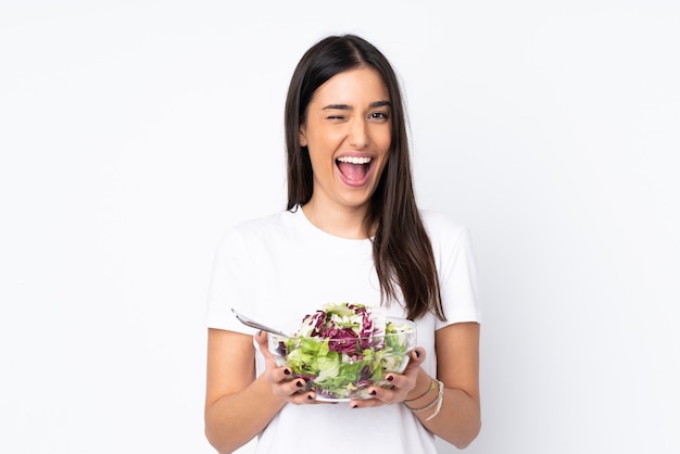 Young woman with salad isolated on white