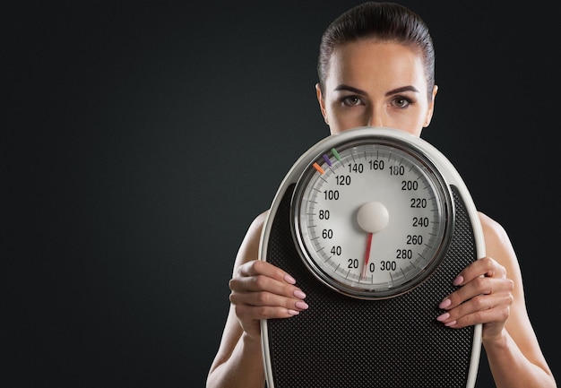 Young woman with scales isolated on background