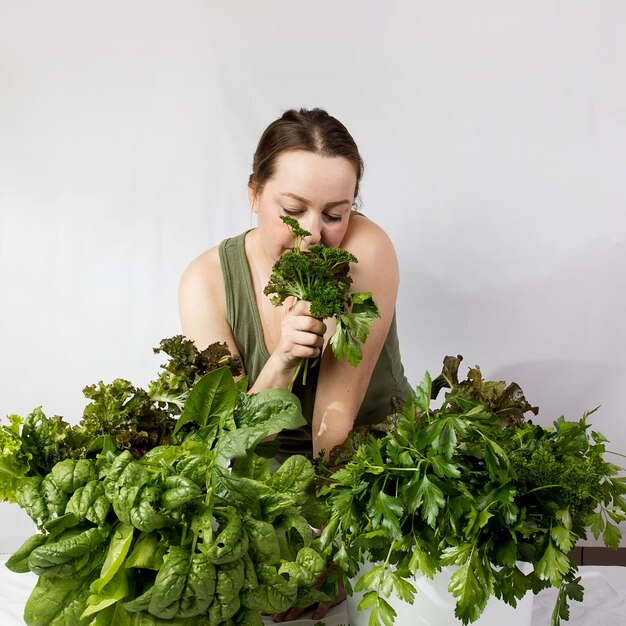 Foto giovane donna con una serie di ingredienti verdi lattuga spinaci per una dieta sana