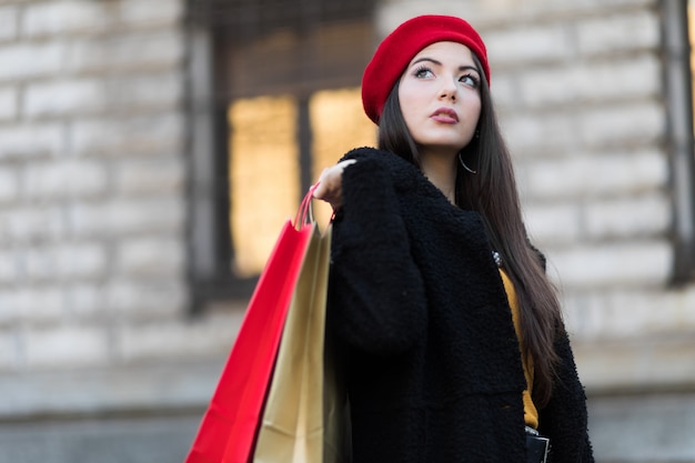 Фото Молодая женщина с сумками и рождественский подарок в милане, италия