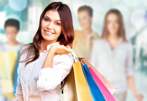 Young woman with shopping bags on  background