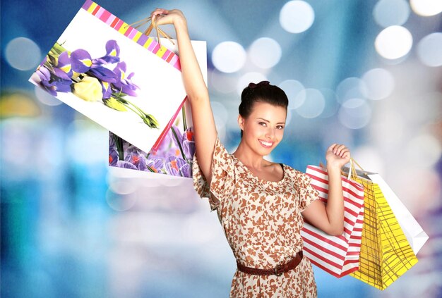 Young woman with shopping bags on  background