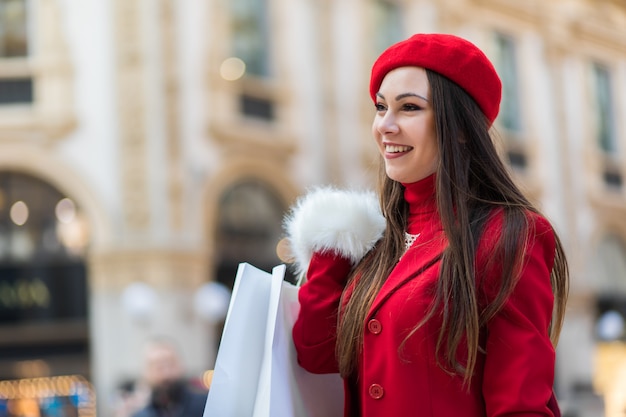 Giovane donna con borse della spesa a milano, italia