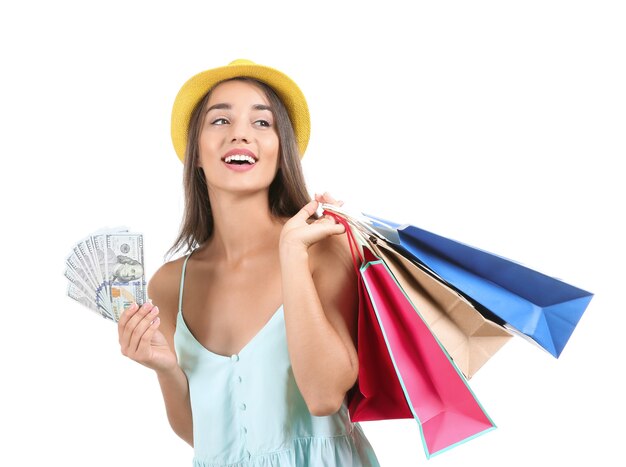 Photo young woman with shopping bags and money on white background