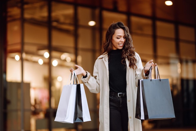 Молодая женщина с сумками возле торгового центра Spring Style Consumerism покупает торговый образ жизни