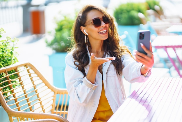 도시 거리 온라인 쇼핑 개념에서 그녀의 전화를 사용하여 쇼핑백을 가진 젊은 여자