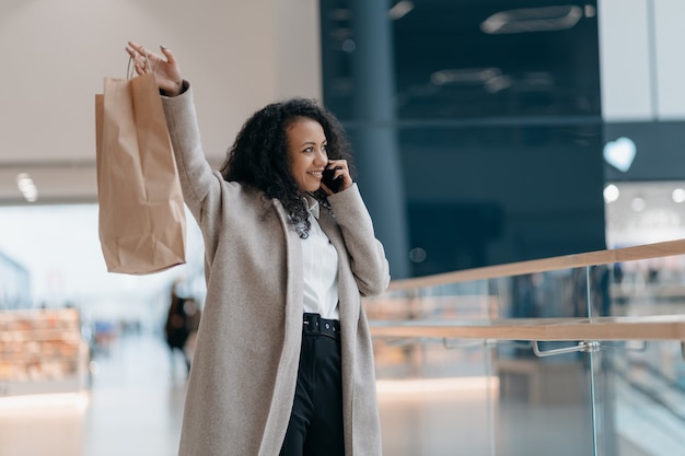 スマートフォンで話している買い物をしている若い女性