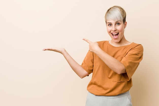 Young woman with short hair excited holding something on palm