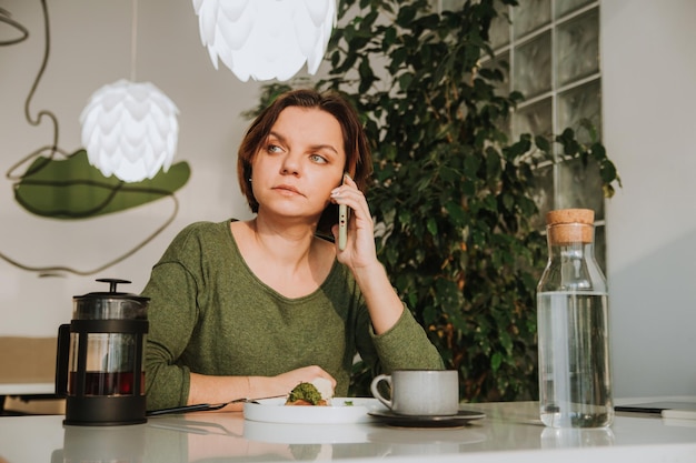 Foto una giovane donna con un taglio di capelli corto è seduta a un tavolo in un caffè