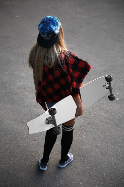 Photo young woman with skating board on the road