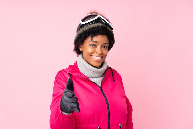 Young woman with ski glasses over isolated wall