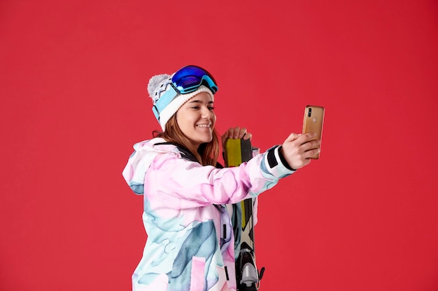 Young woman with skis taking a selfie