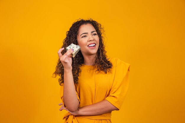 Young woman with a slice of cheese in her hand. woman eating gorgonzola cheese.