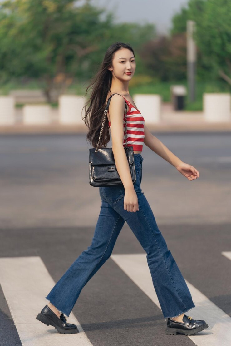 Photo スリングバッグを持った若い女性が道路を横断している