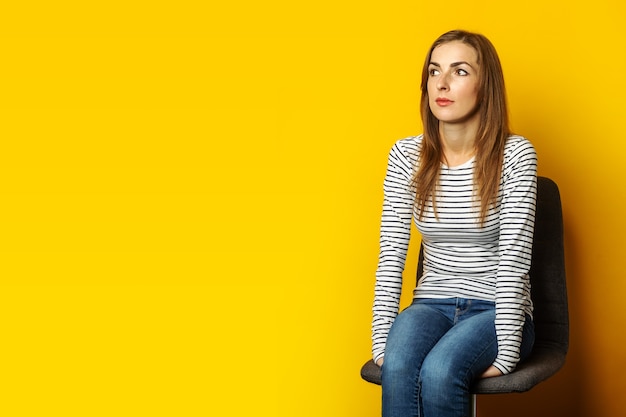 Young woman with a smile sits on a chair