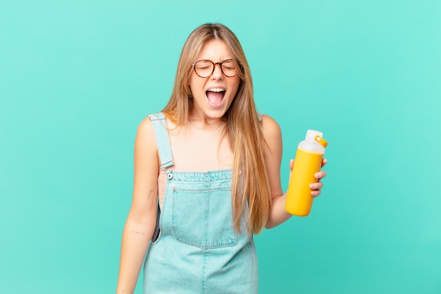 Young woman with a smoothy shouting aggressively, looking very angry