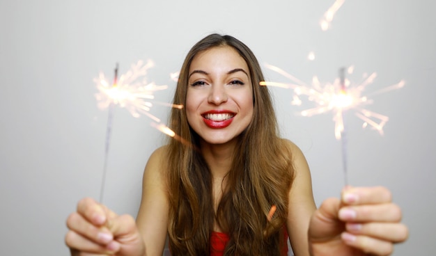 Young woman with sparklers laughing