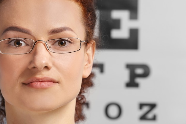 Young woman with spectacles on eyesight test chart