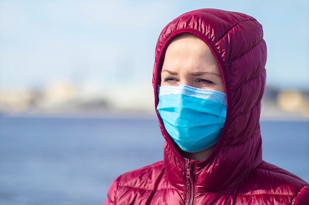 Young woman with sterile medical protective mask on her face