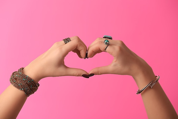 Young woman with stylish bijouterie making heart with her hands