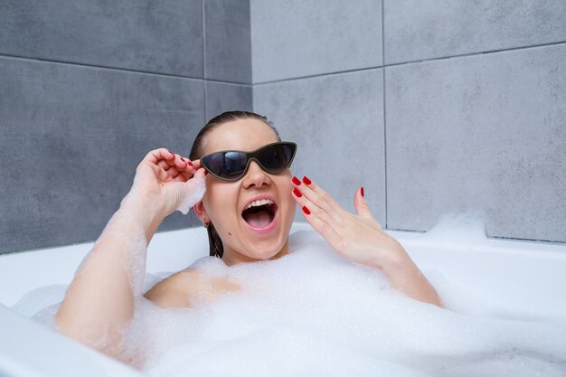 Young woman with sunglasses getting spa treatment in a beauty salon, inside an interior room. Relax in the bathroom without linen. Body care and relaxation concept.