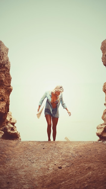 Young woman with surfboard standing at beach