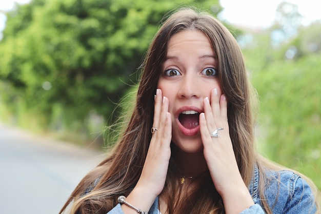 Young woman with surprised expression. Outdoor.