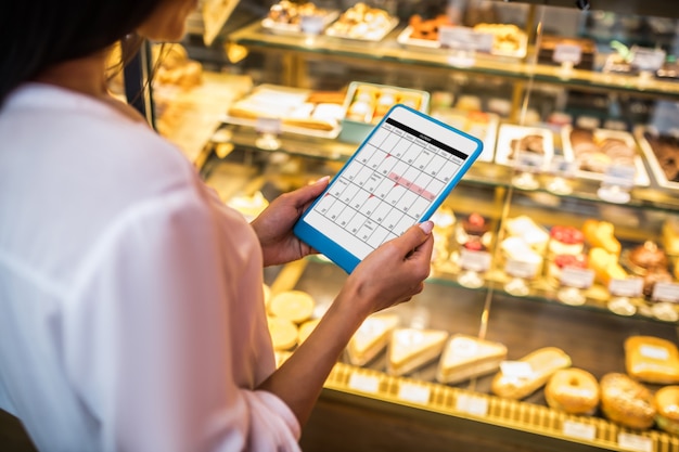 Young woman with a tablet in a bakery