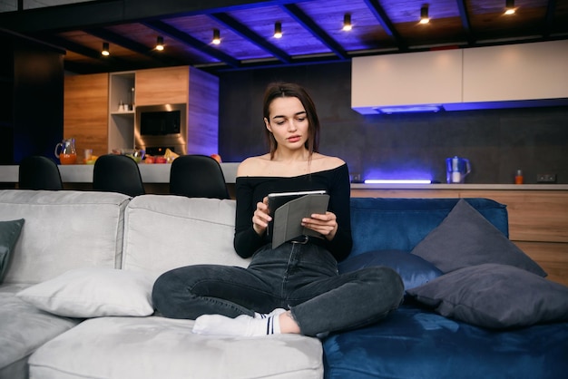 Photo young woman with tablet pc on the sofa