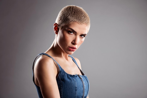 Young woman with tattoos arm and short hair in studio