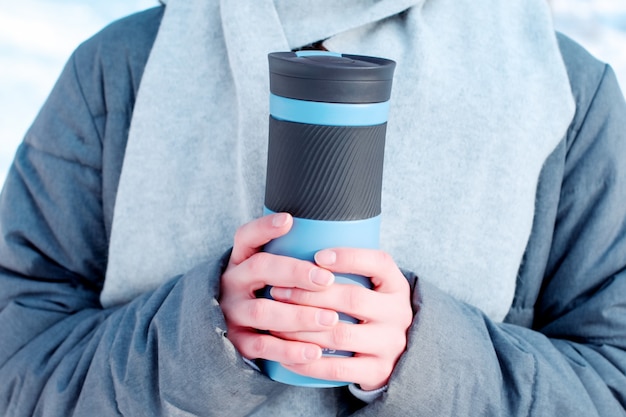 Young woman with thermos cap