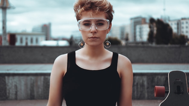 Photo young woman with trendy short blonde hair and plastic glasses outdoor portrait at city