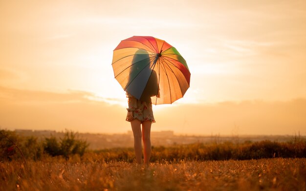 Young woman with umbrella in the field